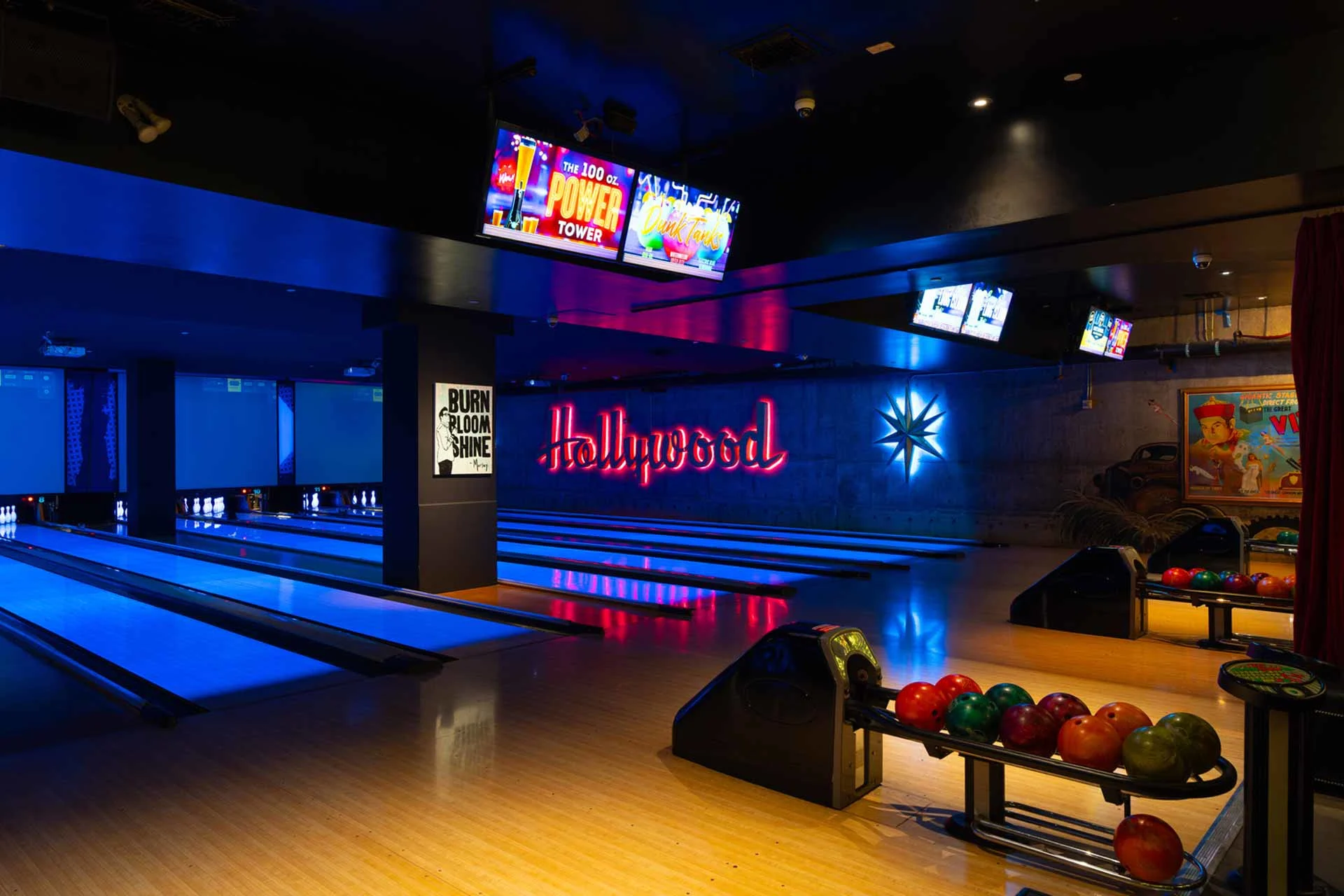 Clean, modern lane setup with bold neon signage and polished wood finishes. Balanced lighting and clear sightlines create a classic yet elevated bowling experience.