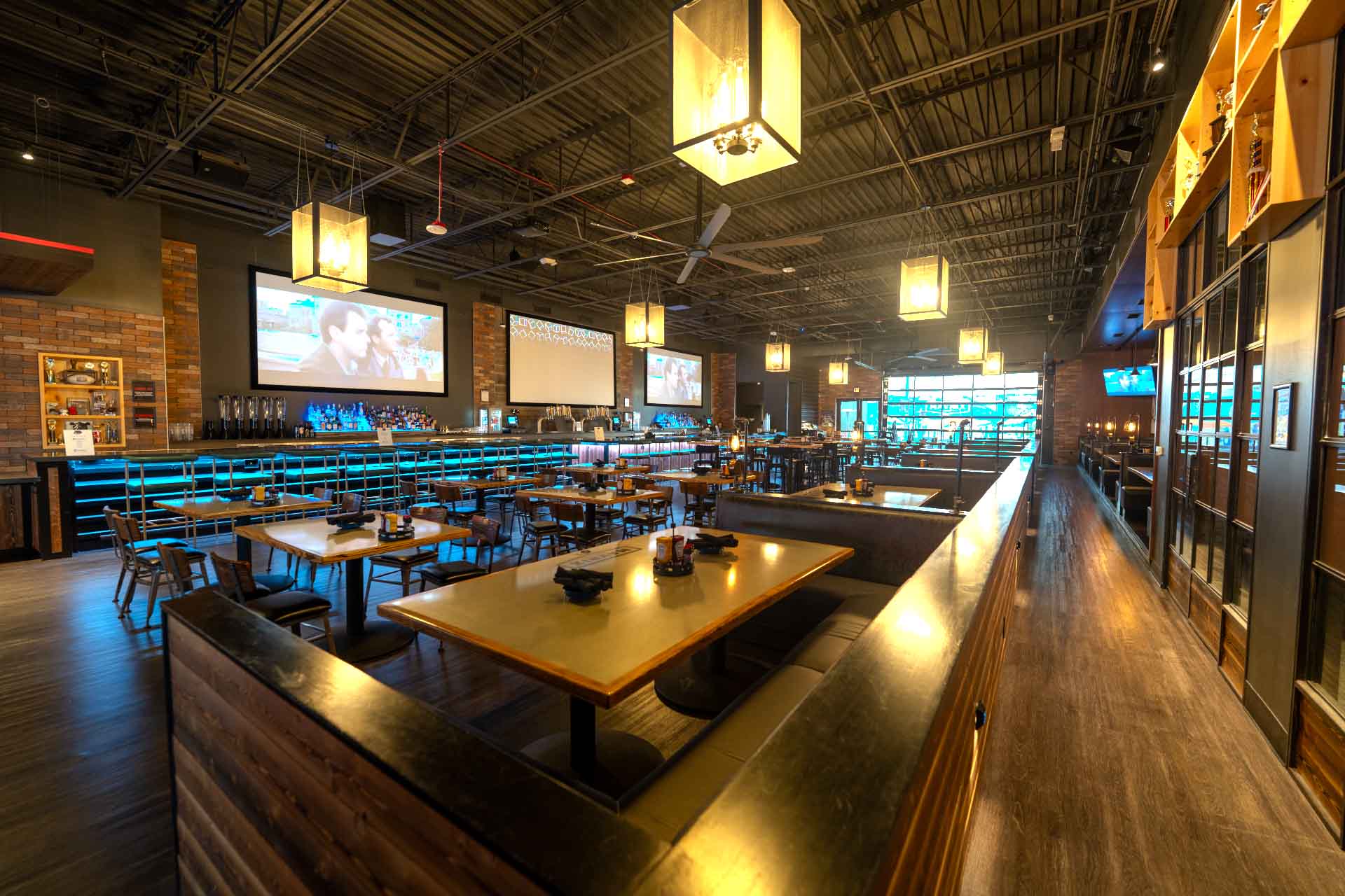 Spacious bar and dining area at Mavrix Entertainment Center with tables, TVs, and warm lighting.
