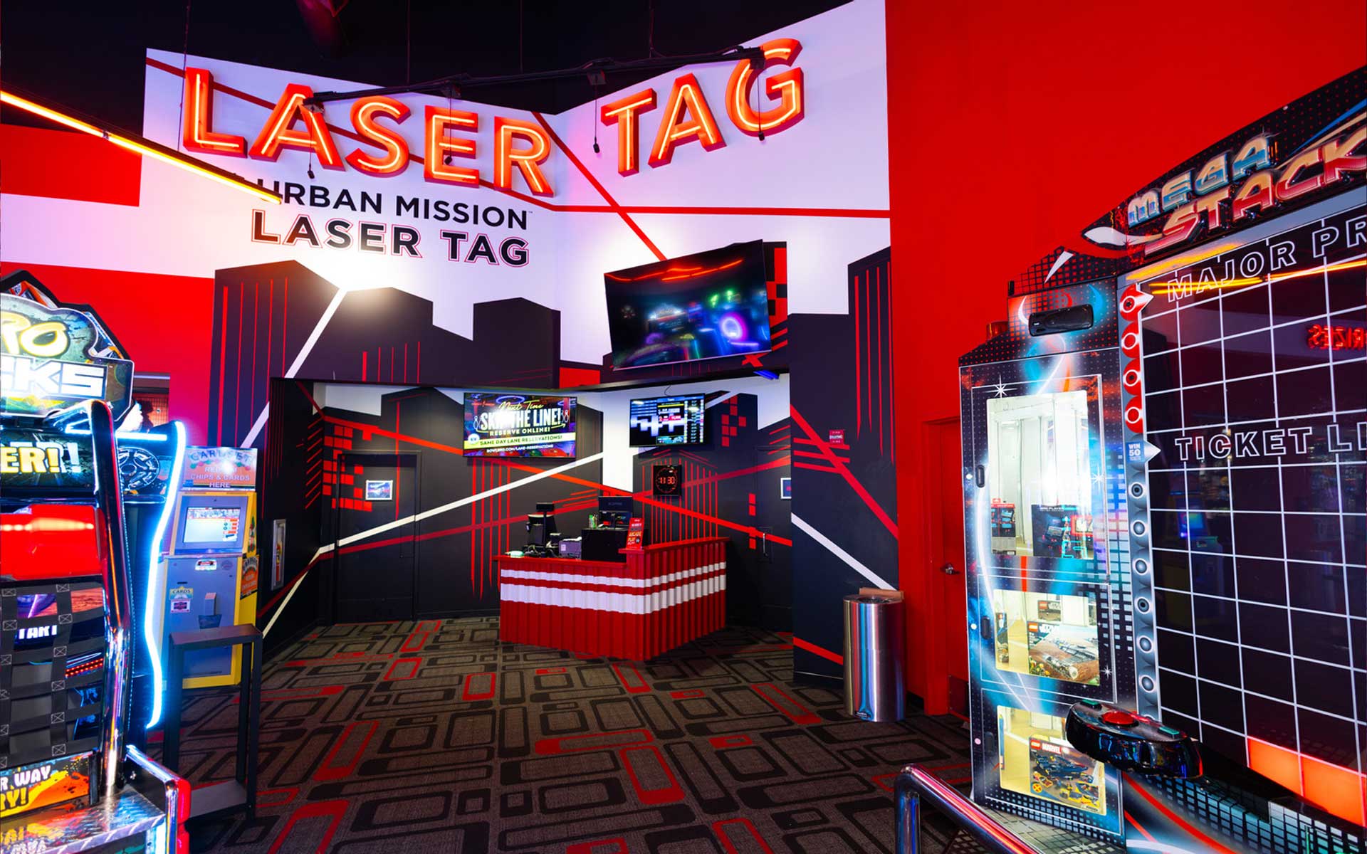 Laser tag entrance at Lucky Strike with bold wall graphics, illuminated signage, arcade machines, and a futuristic entertainment setting.