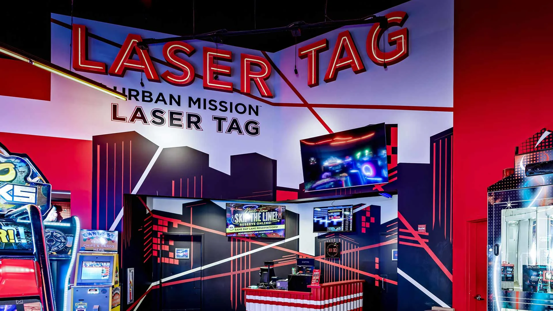 Laser tag entrance at Lucky Strike with bold wall graphics, illuminated signage, arcade machines, and a futuristic entertainment setting.