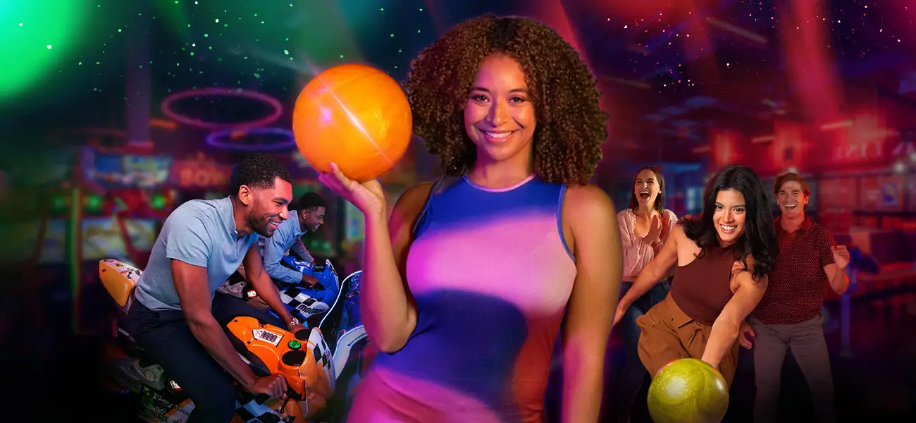 Woman holding bowling ball with bowling and arcade games in the background