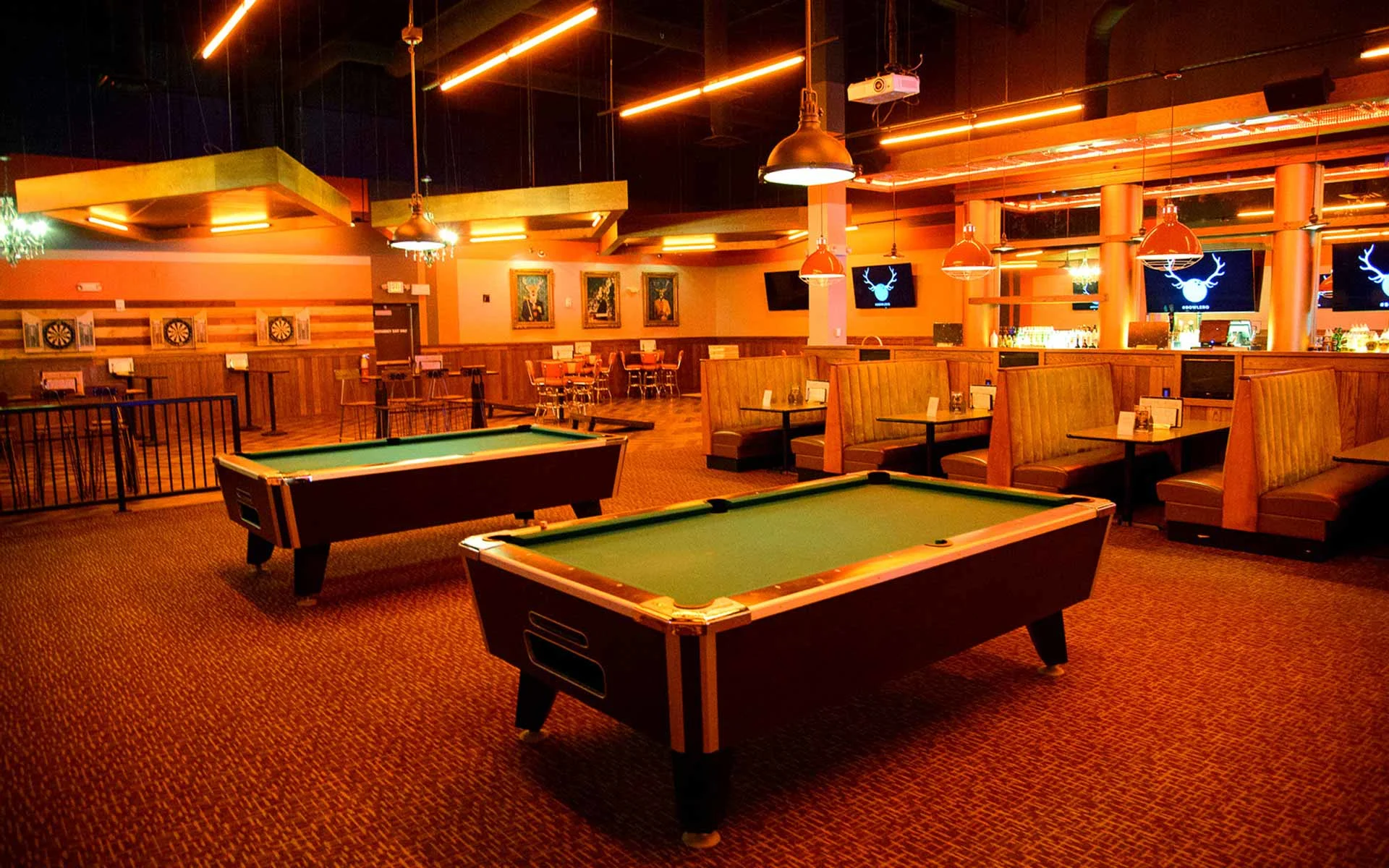 Stylish lounge area with pool tables, booth seating, and warm lighting in a modern Lucky Strike bowling and entertainment venue