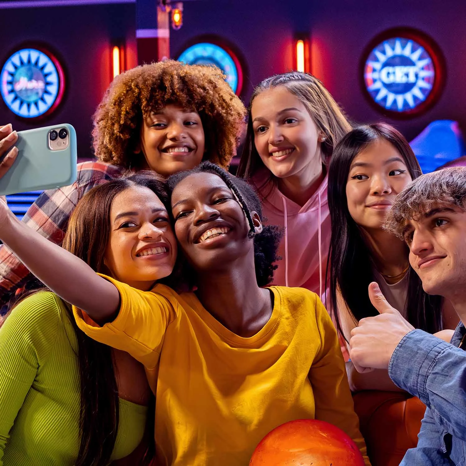 Group of teens taking a selfie with bowling lanes in the background