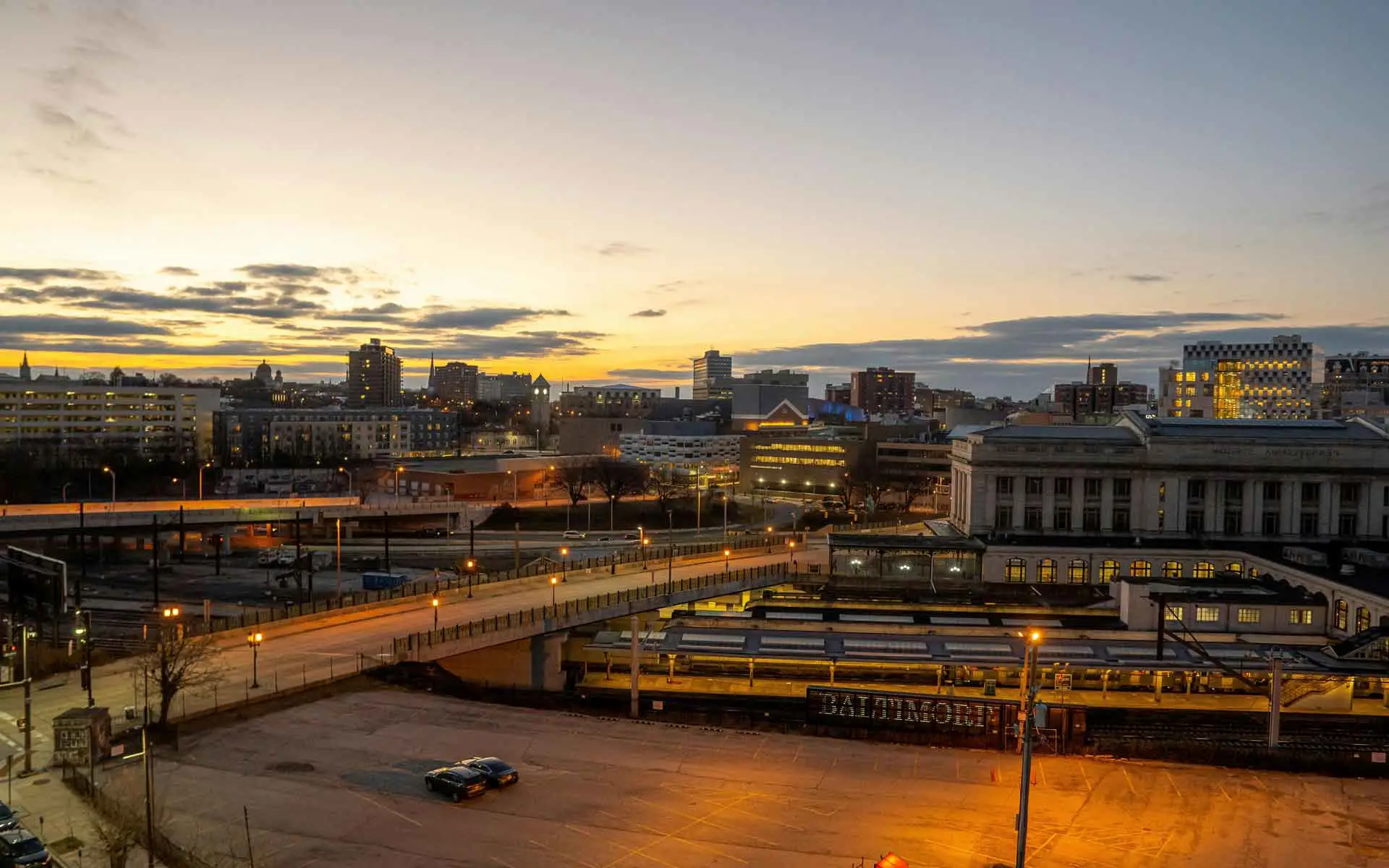 Baltimore skyline at sunset with Penn Station and city lights.
