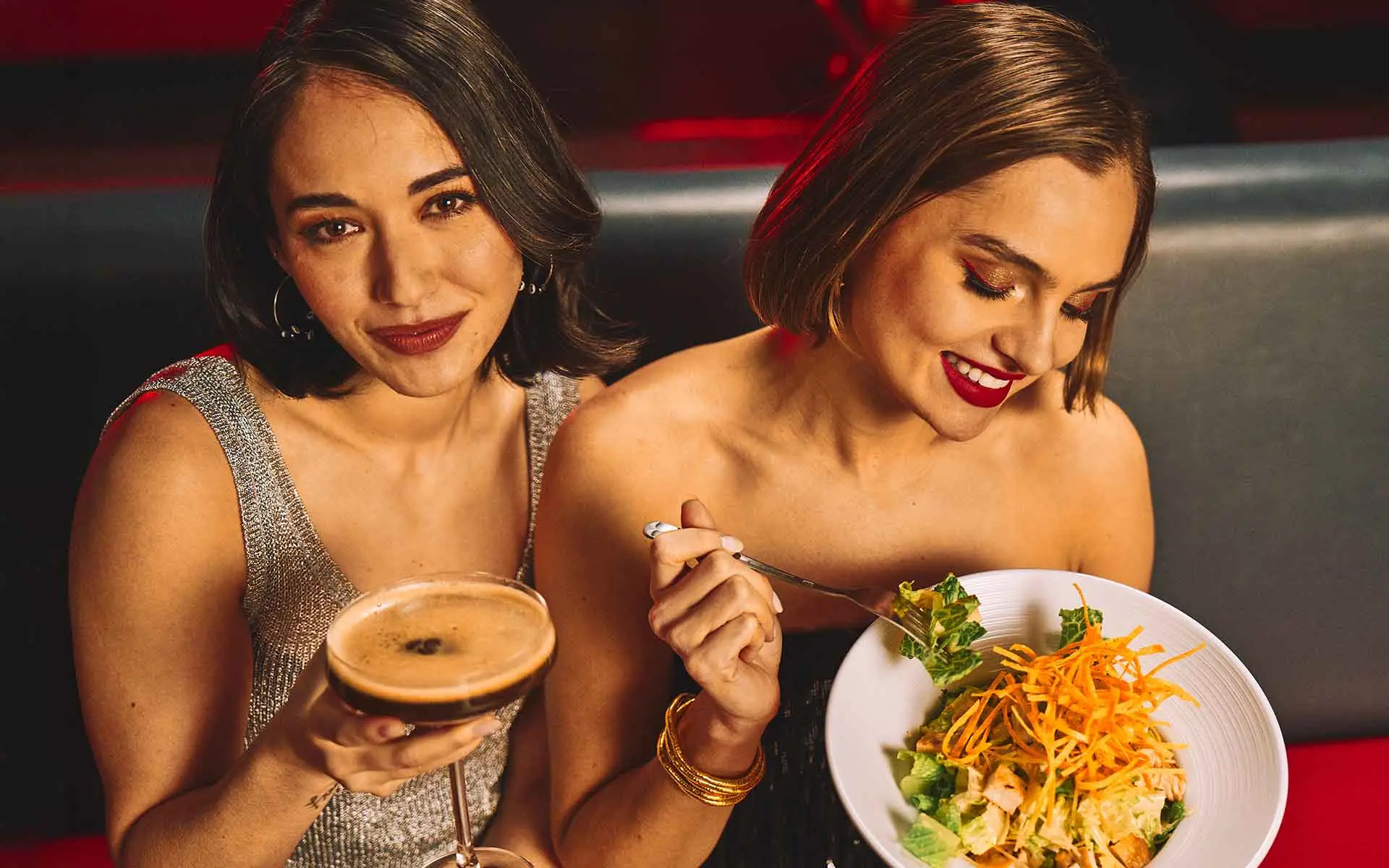 Two women enjoying a drink and food