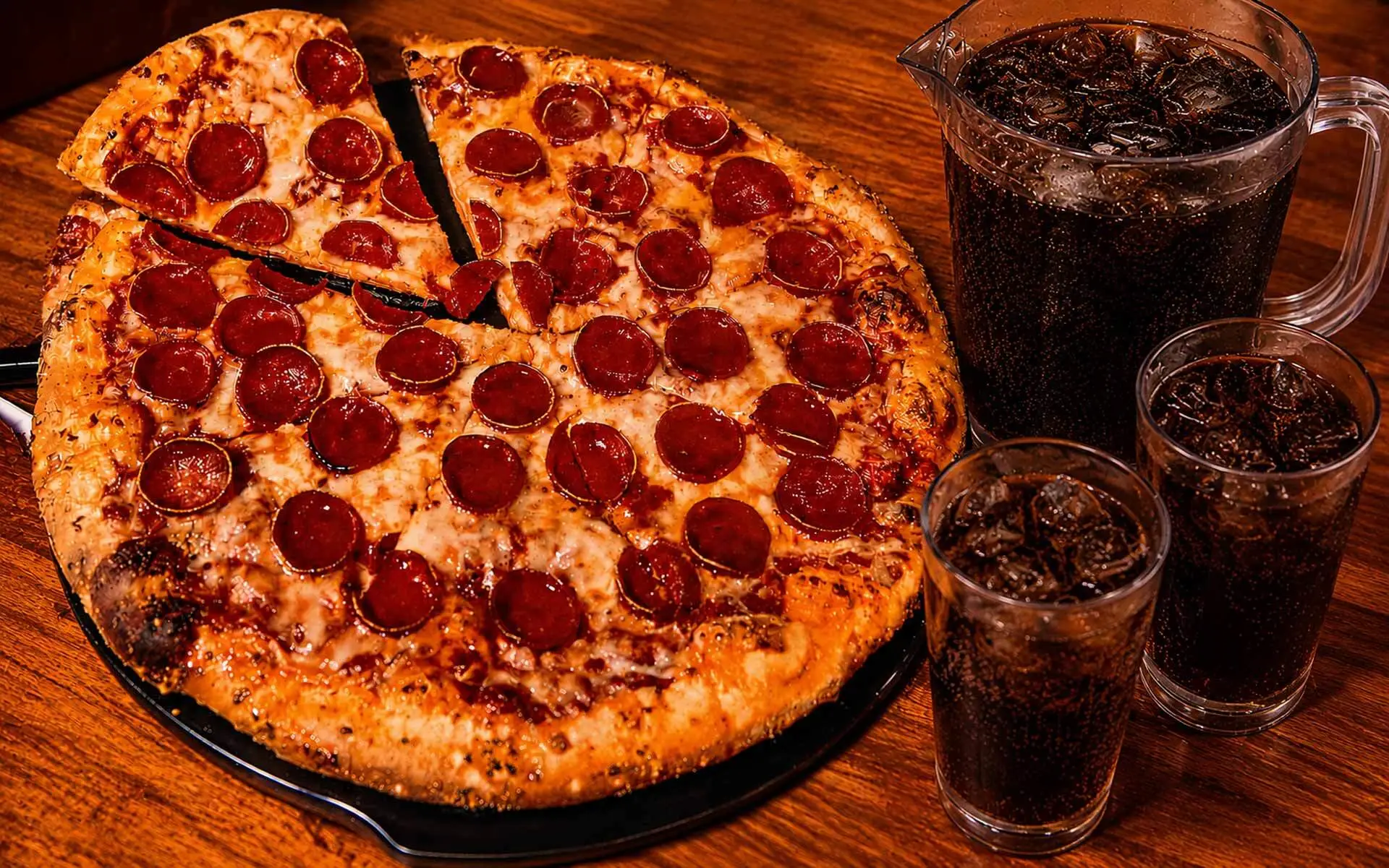 Pepperoni pizza with a pitcher of soda