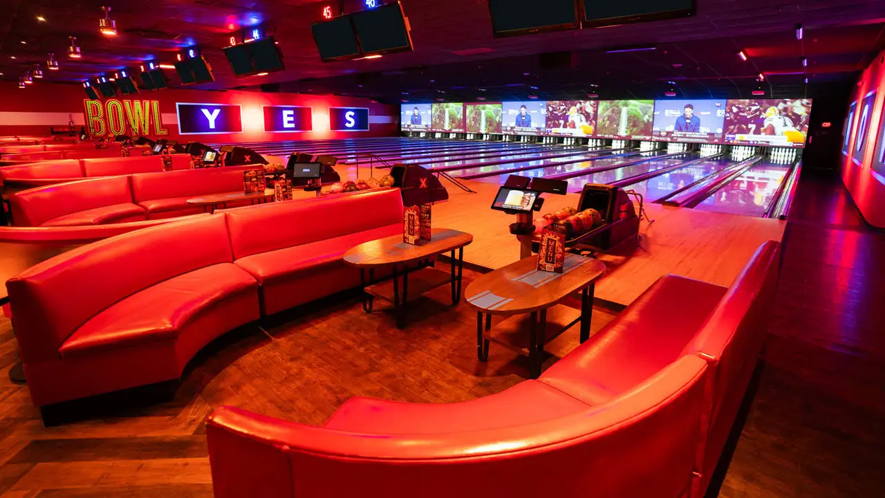 Beautiful bowling lanes with lights and large TV screens above the lanes