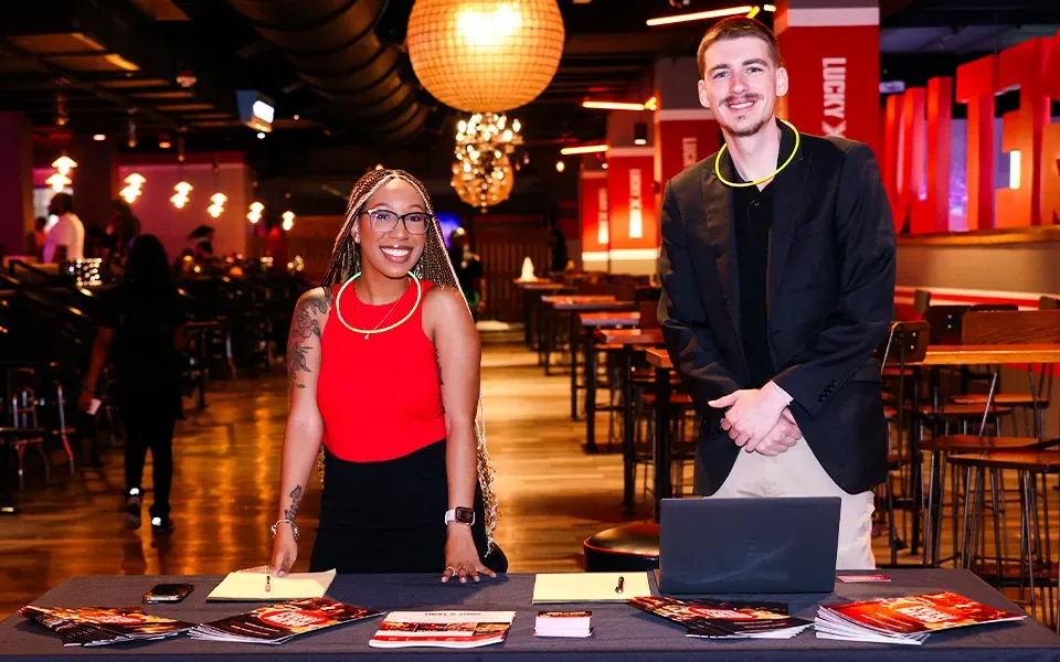 Woman and man standing behind a table and smiling