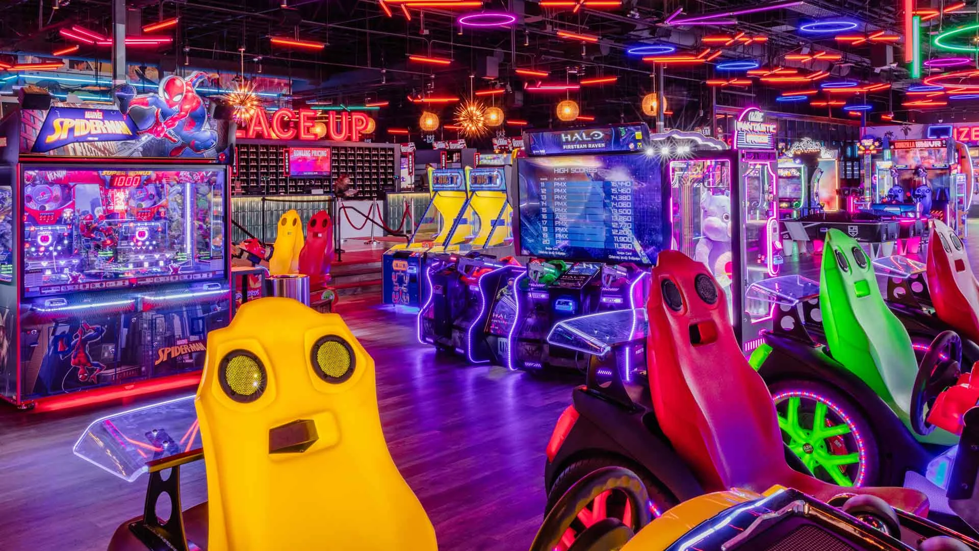 Interactive arcade at Lucky Strike with racing games, pinball machines, and colorful LED lighting.