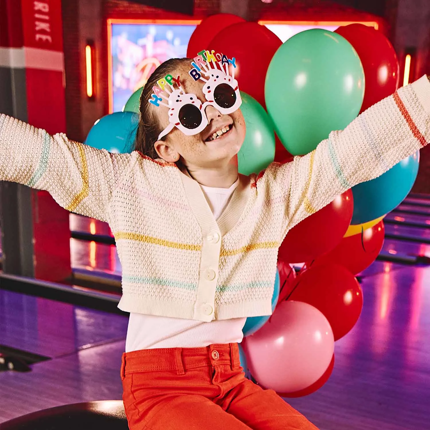 Child celebrating birthday with balloons at Lucky Strike.