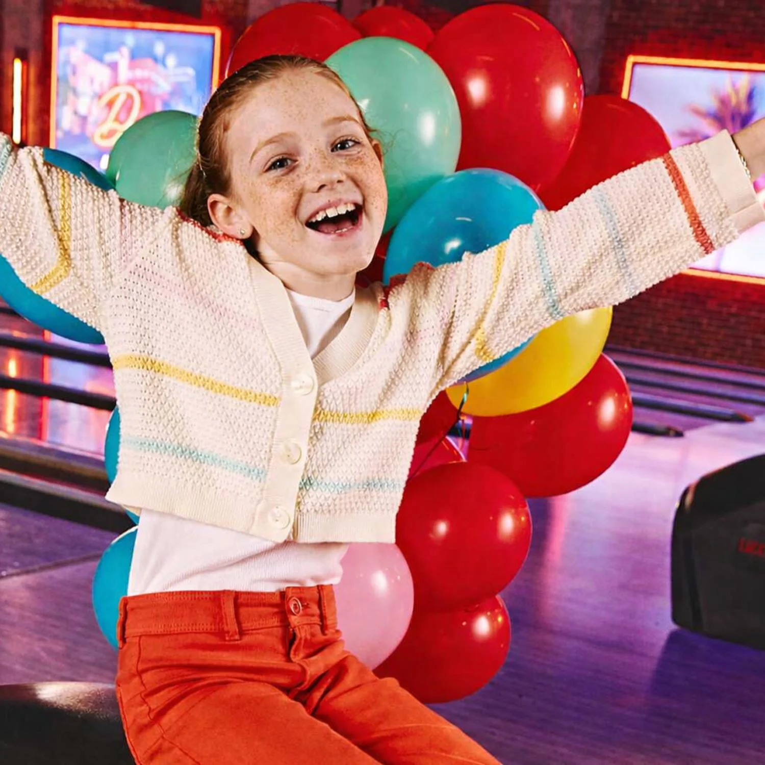 Child celebrating birthday with balloons at Lucky Strike.