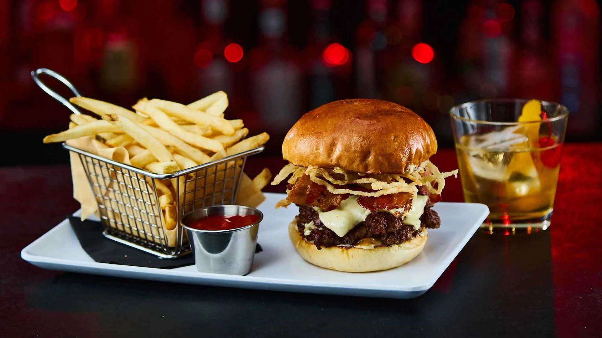 Delicious cheeseburger, basket of fresh french fries, and a drink.