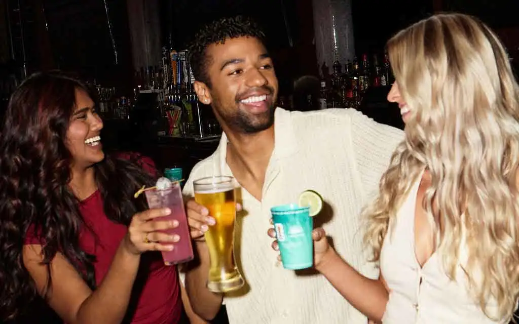 Friends laughing and holding drinks at the Lucky Strike bar