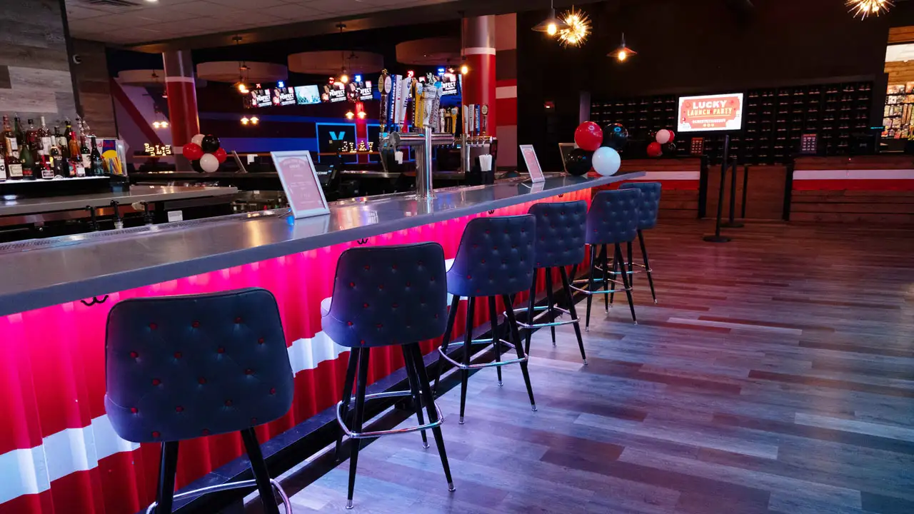 Beautiful bar with lots of seating and a large bowling center in the background