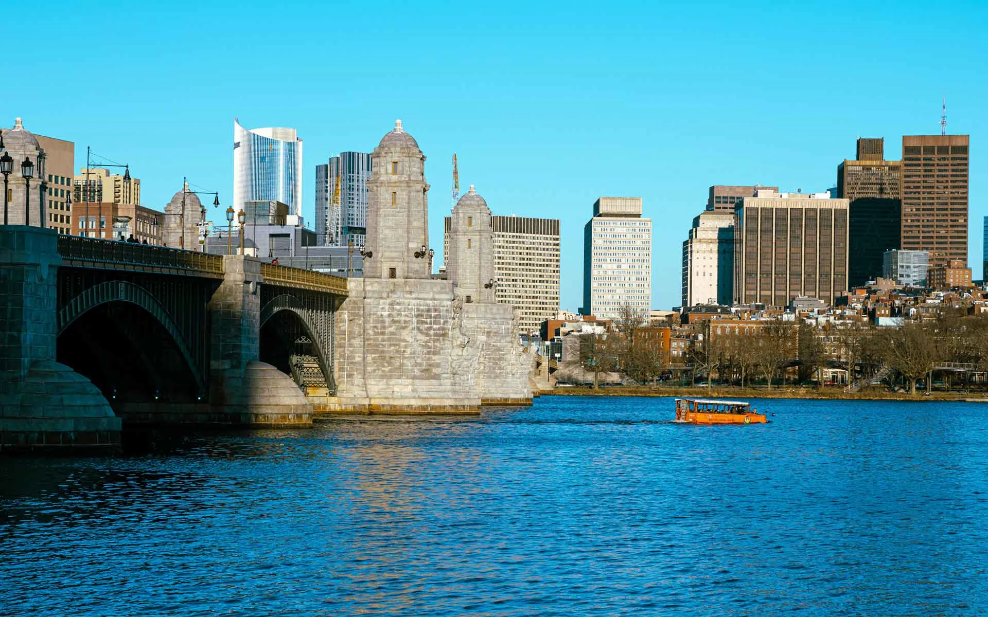 Boston skyline and Charles River with historic bridge architecture and downtown cityscape views.