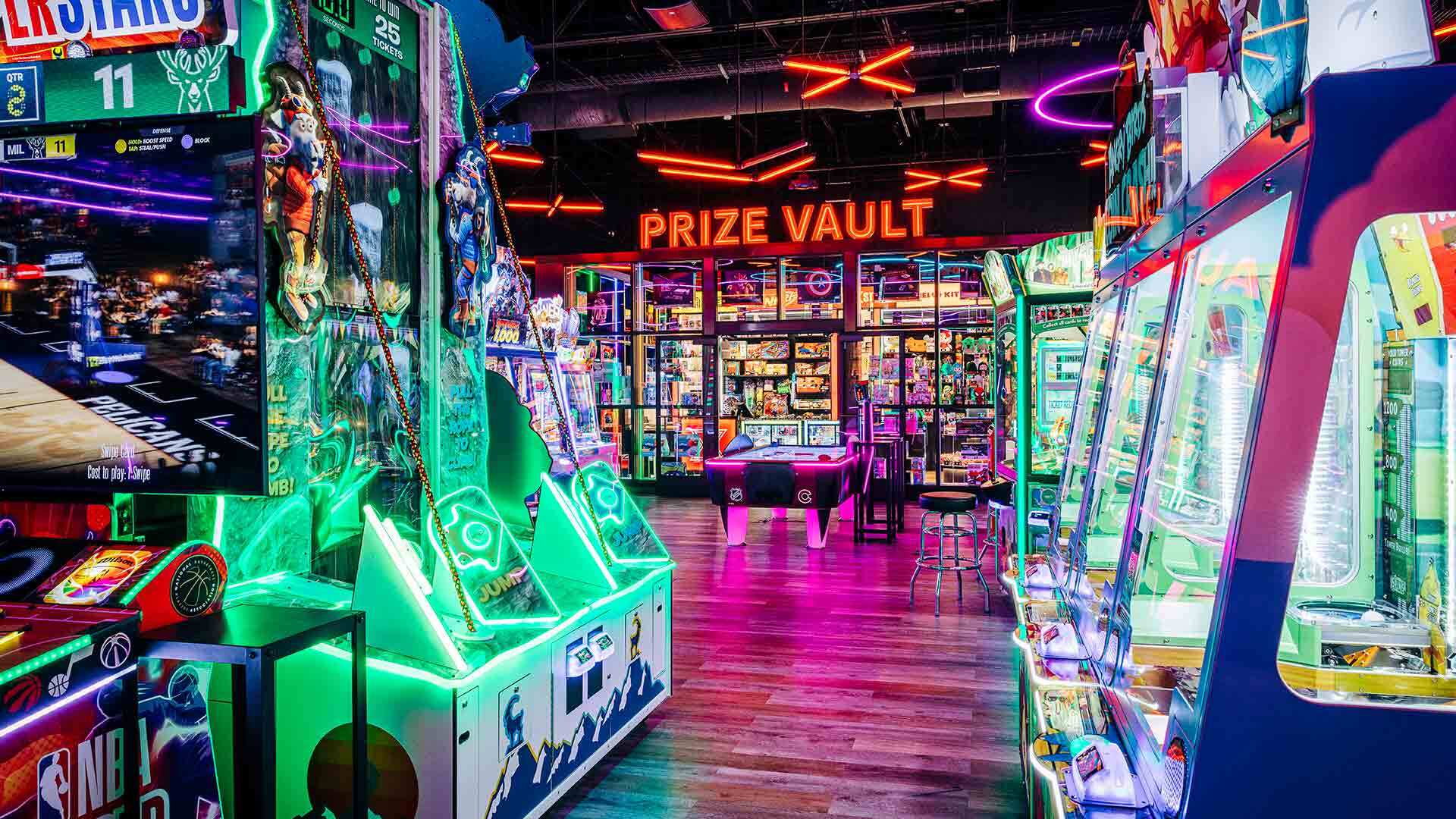Colorfully-lit arcade with many big games and a prize vault.