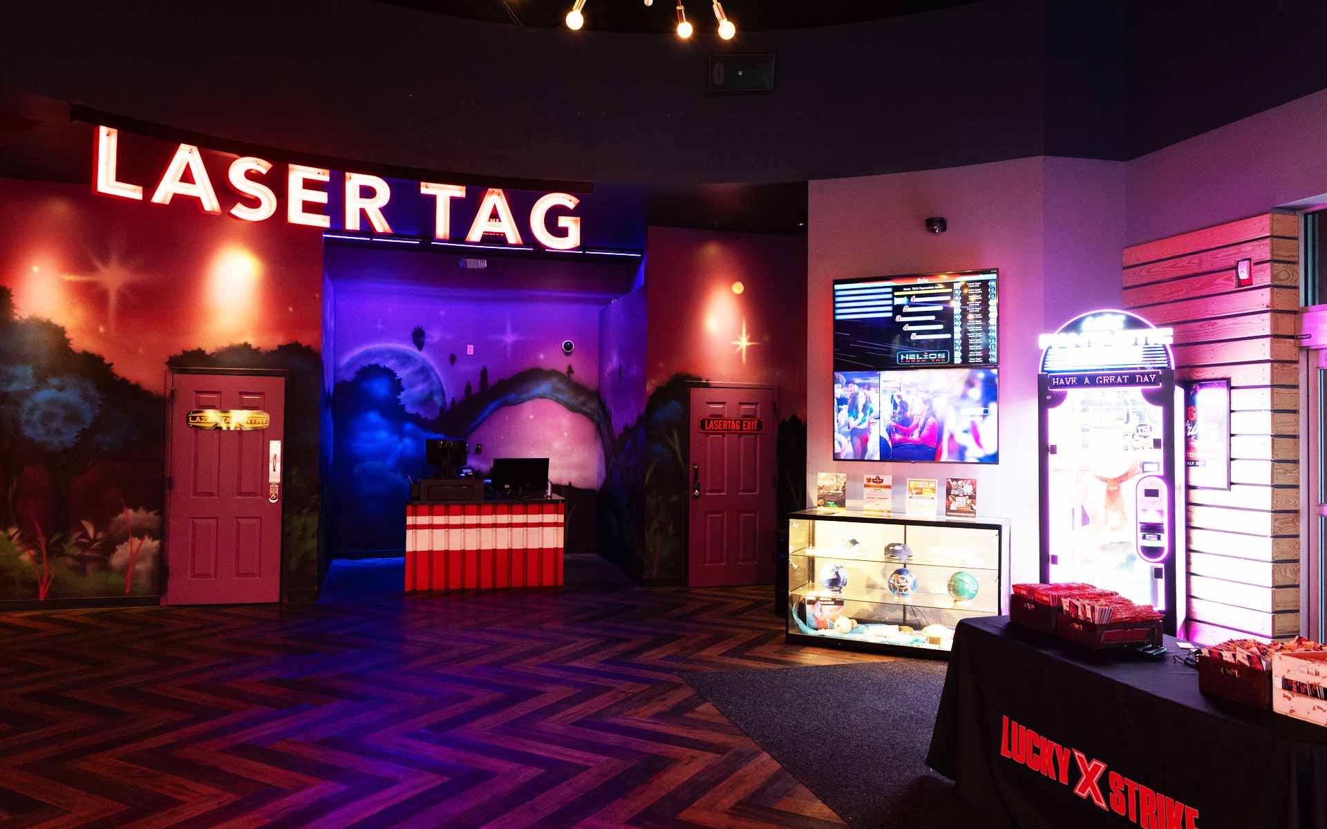 “Laser Tag” entrance area at Lucky Strike with neon signage, game check-in desk, and colorful mural lighting.