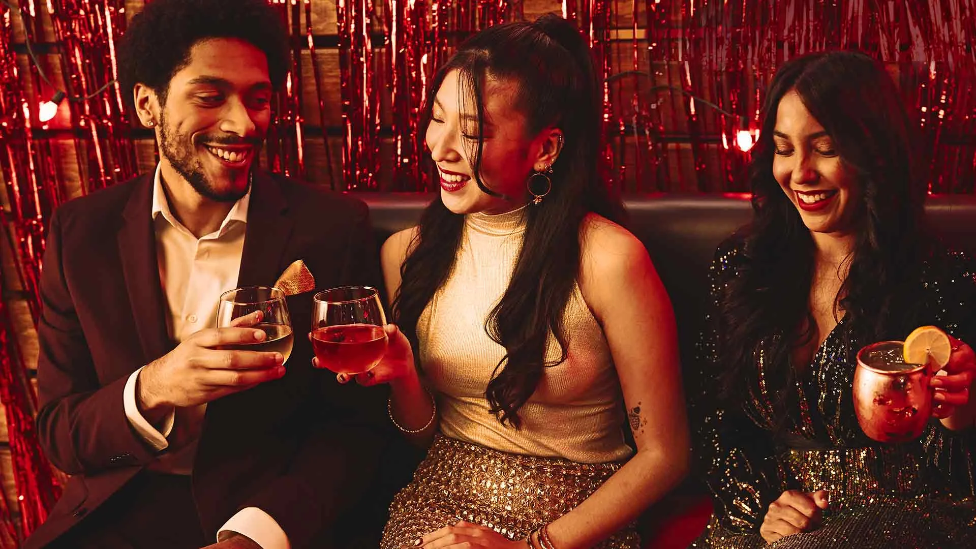 Group in formal attire enjoying cocktails at corporate party.