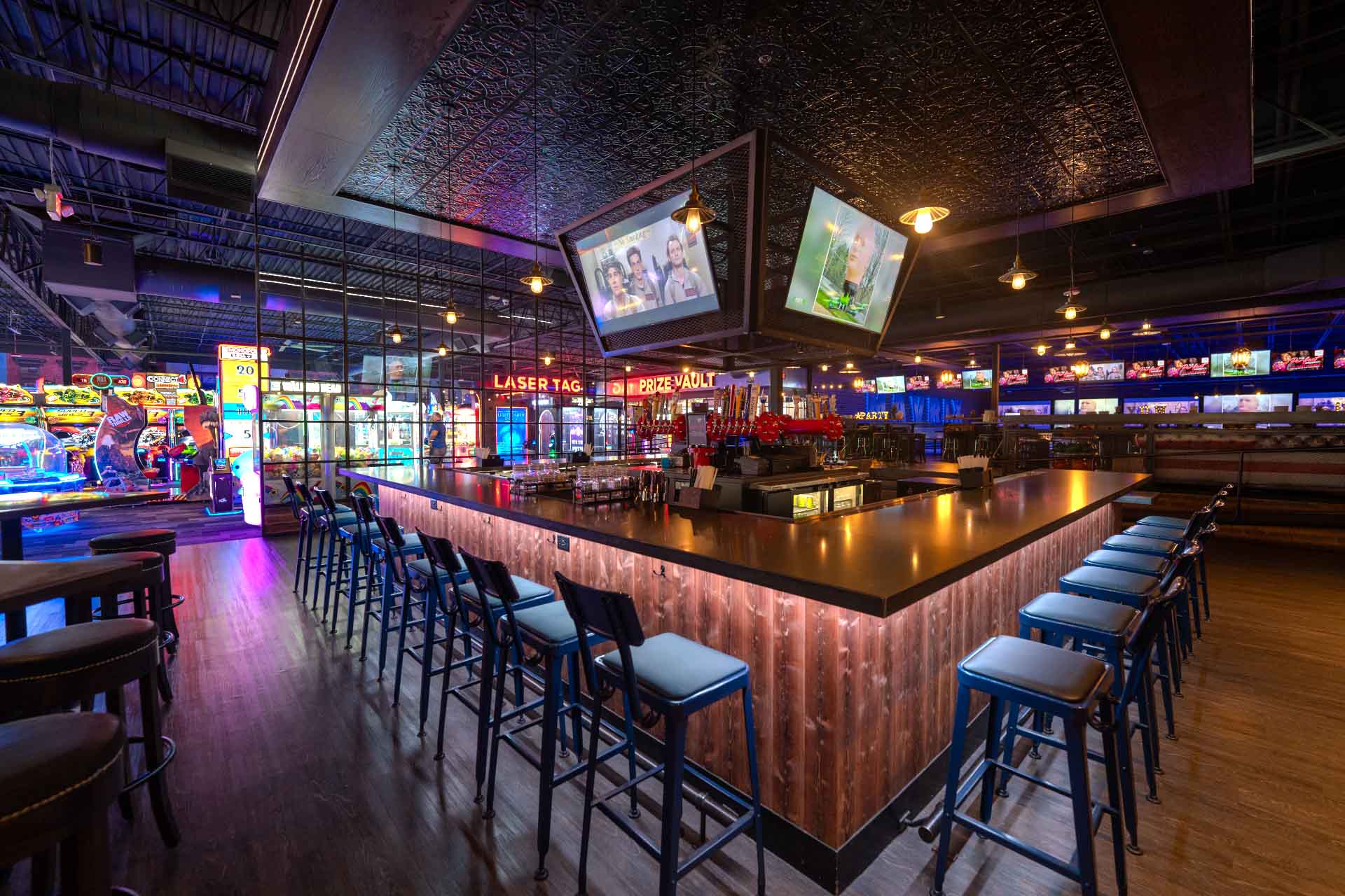 Full-service bar at Mavrix Entertainment Center with seating, large screens, and modern design.