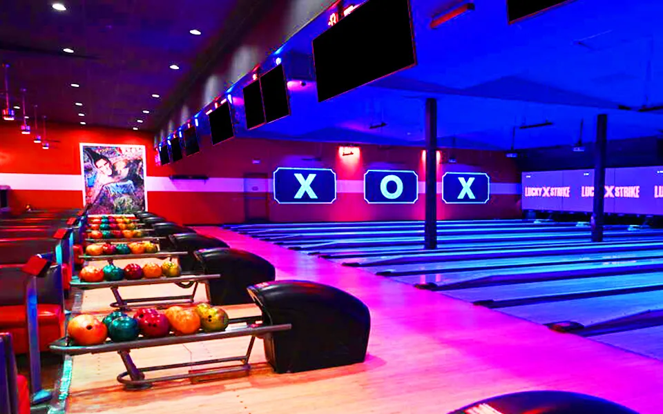 Colorful bowling balls lined up on bowling ball rack returns.