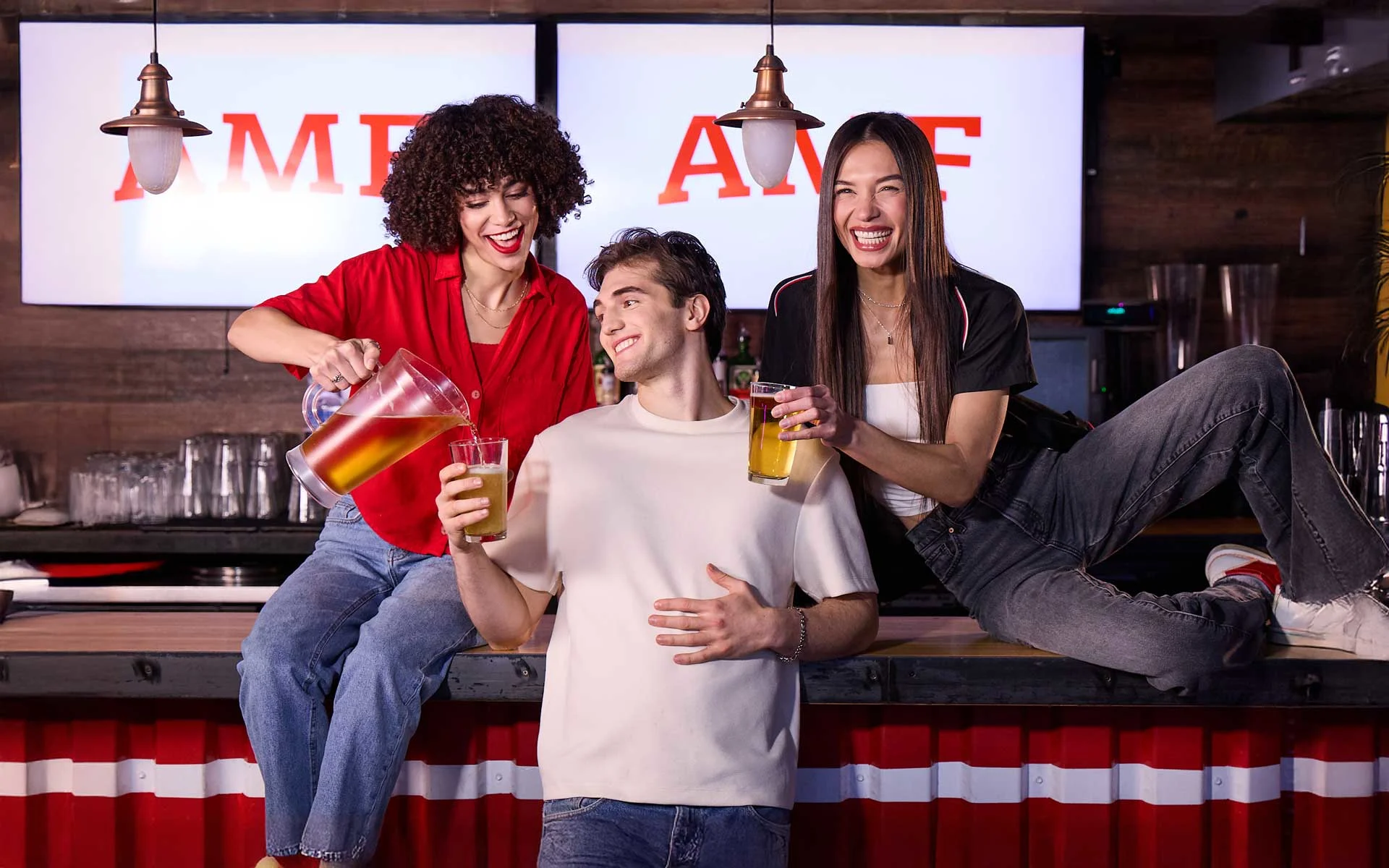 Modern AMF bowling center bar with industrial design elements, featuring rows of bowling pins and overhead machinery in the foreground with guests and AMF branding visible in the background.