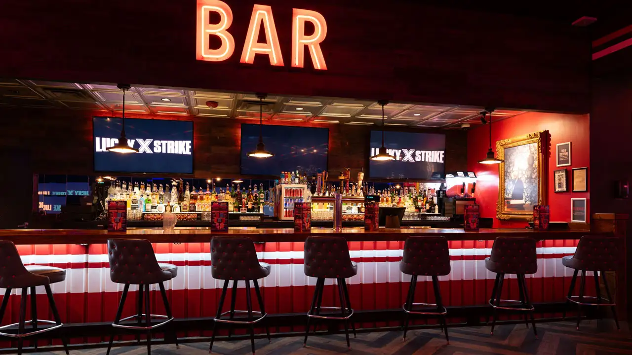 Beautiful bar with lots of seating and large TV screens above the bar
