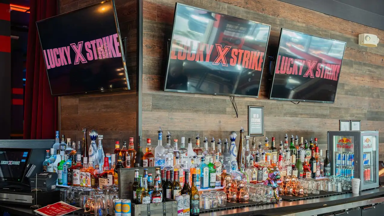 beautiful, fully-stocked bar with large TV screens
