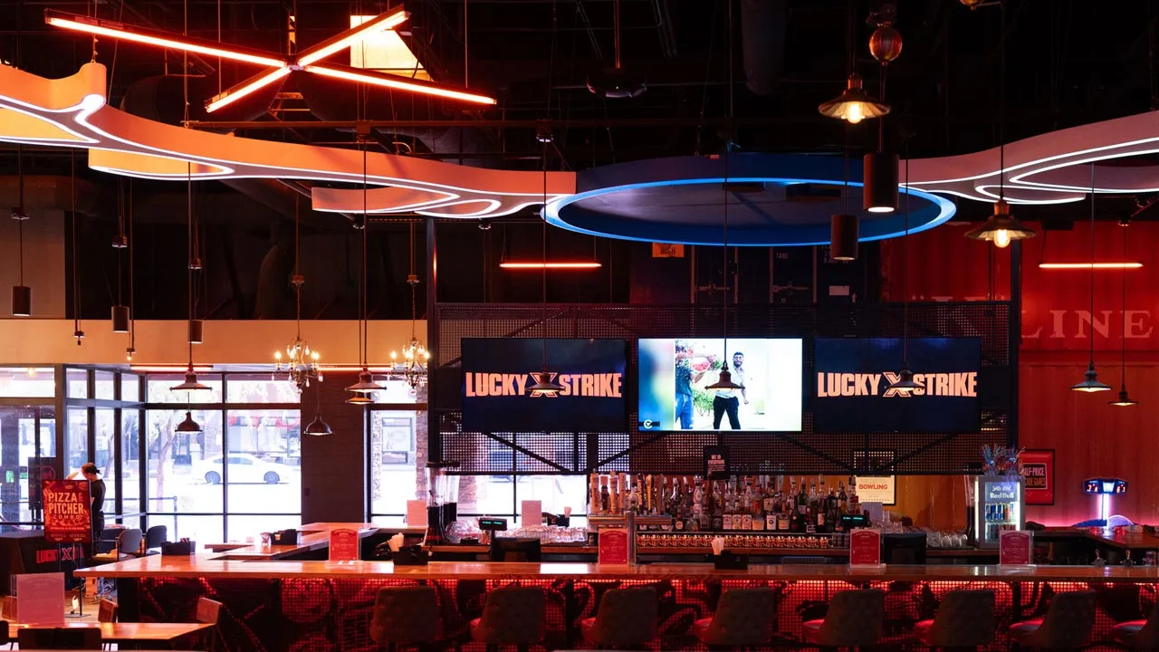 Beautiful bar with lots of seating and large TV screens above the bar.