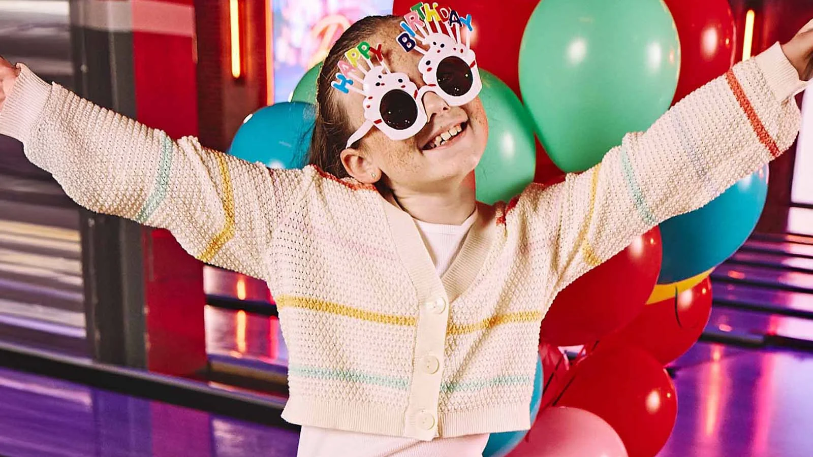 Child celebrating birthday with balloons at Lucky Strike.
