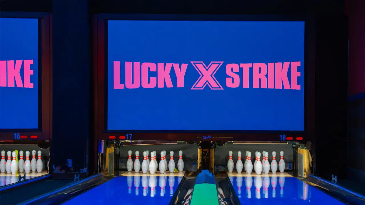 Beautiful lanes with black lights and a large TV screen above the lanes.