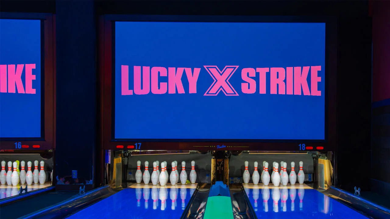 Beautiful lanes with black lights and a large TV screen above the lanes.