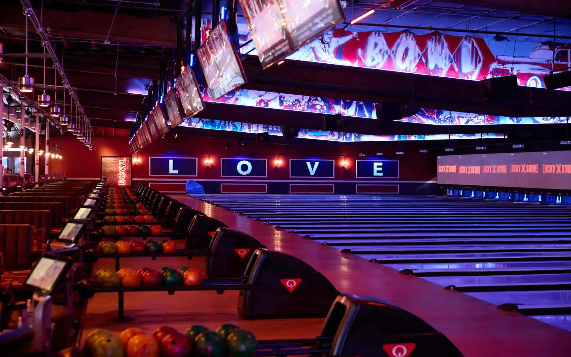 Bowling lanes at Lucky Strike Los Angeles with LOVE wall signage, LED ceiling displays, and Lucky Strike branded scoring screens