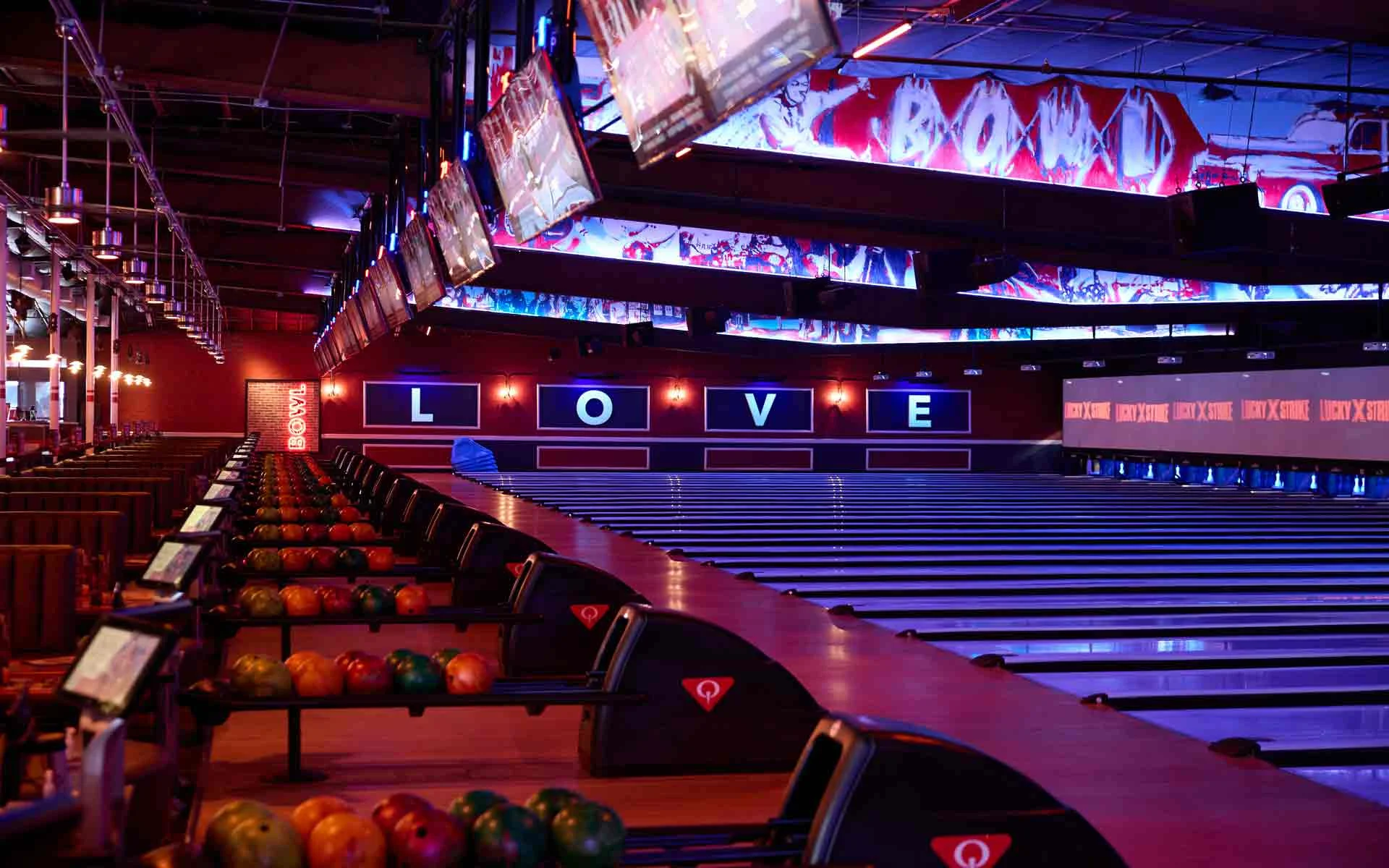 Bowling lanes at Lucky Strike Los Angeles with LOVE wall signage, LED ceiling displays, and Lucky Strike branded scoring screens