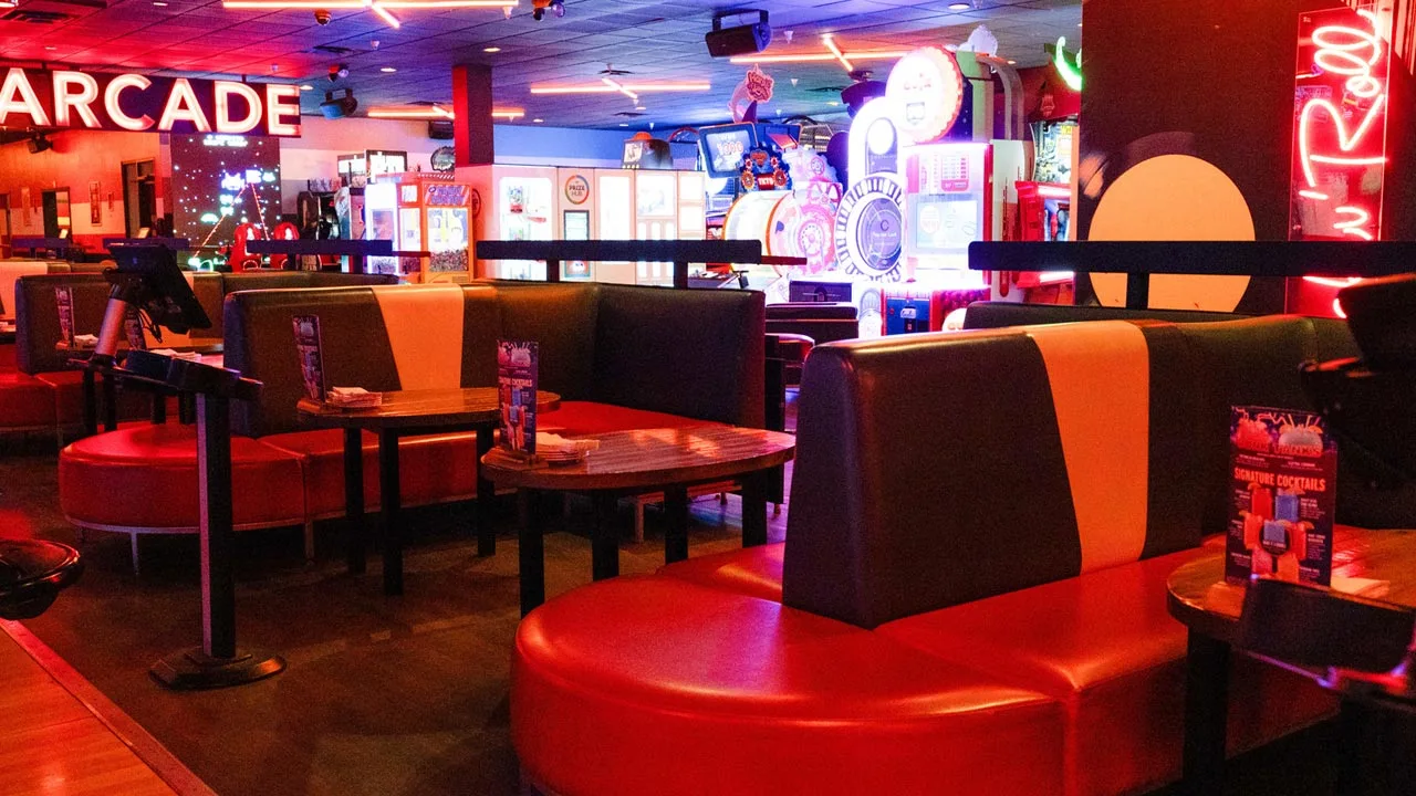 Spacious and comfortable lane-side seating with a colorful bowling arcade in the background