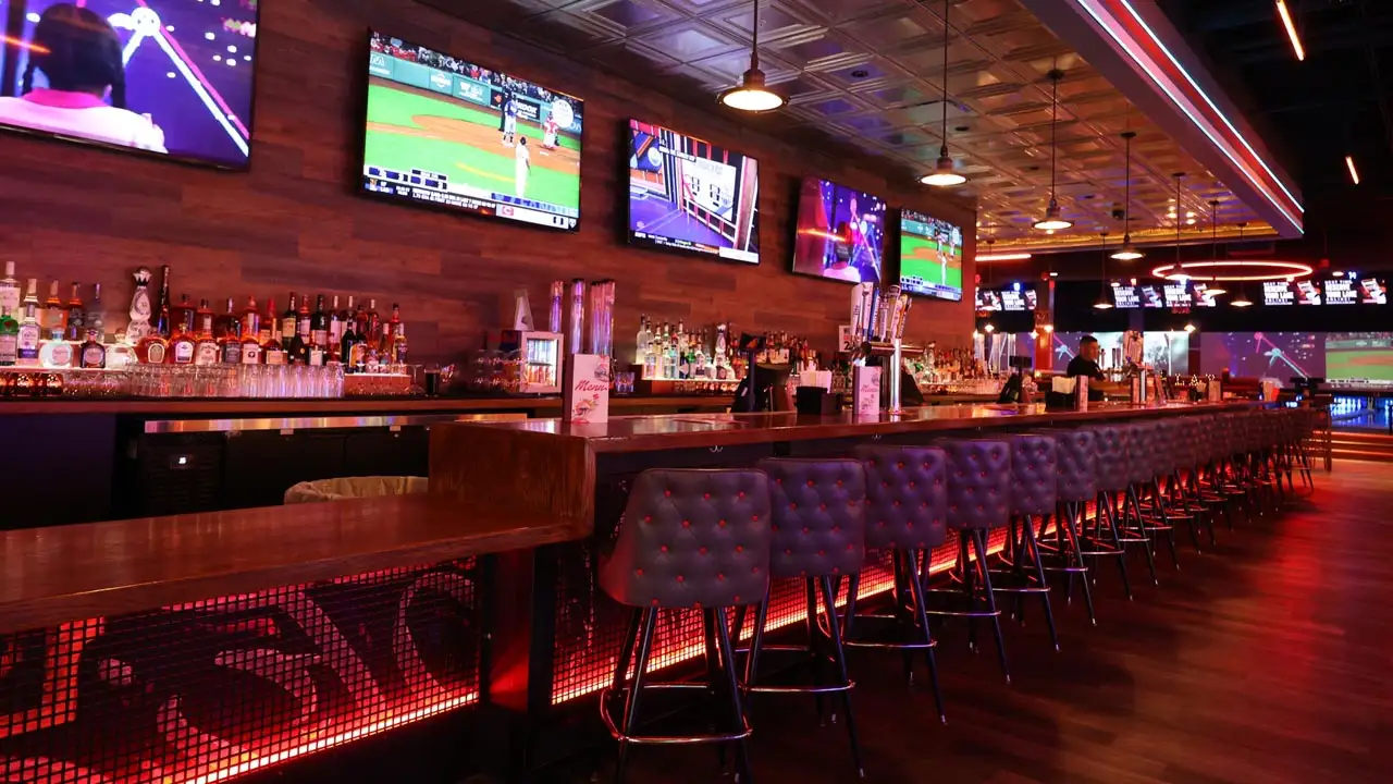Beautiful bar with lots of seating and large TV screens above the bar