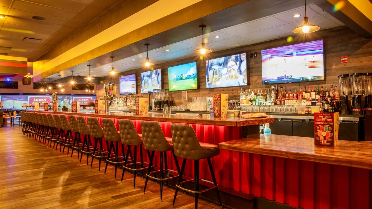 Beautiful bar with lots of seating and large TV screens above the bar