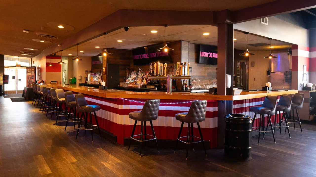 Beautiful bar with lots of seating and large TV screens above the bar