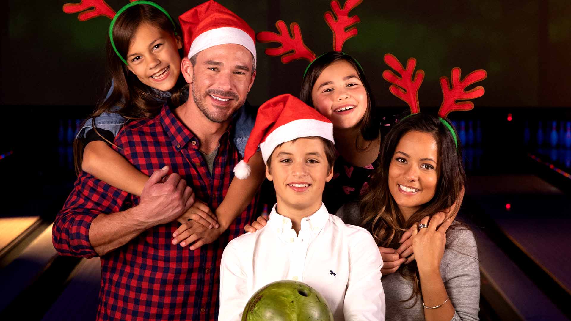 Family wearing Santa hats and reindeer antlers.