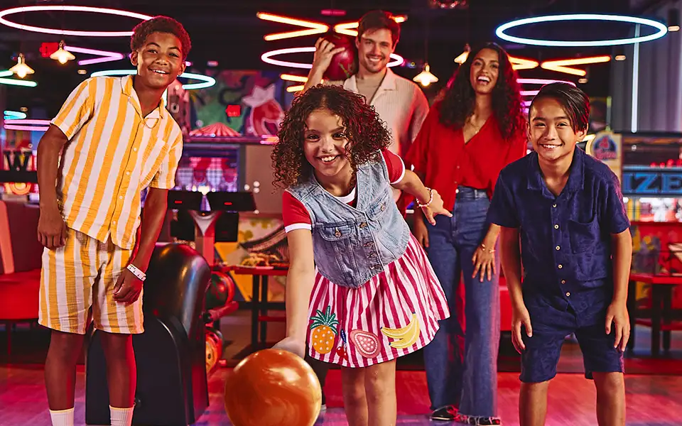 Group of bowlers having fun with a bowling center in the background.
