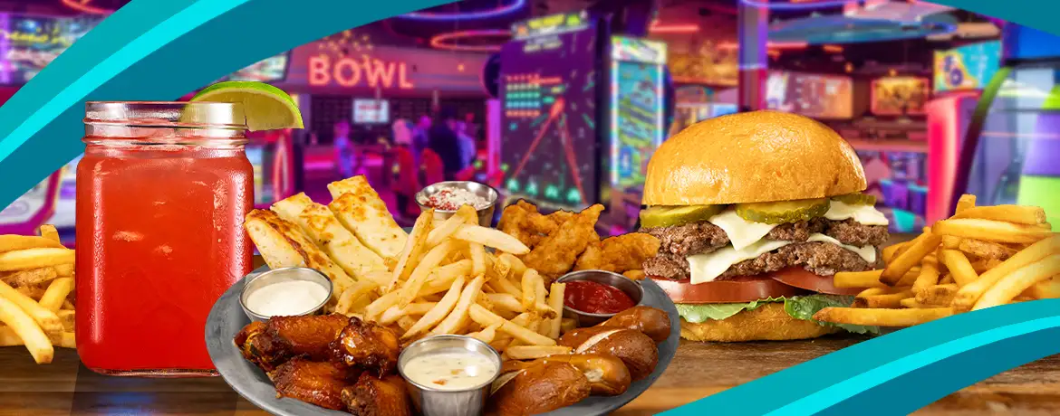Delicious wings, fries, tenders, and burger with drink at a lively bowling center and arcade.