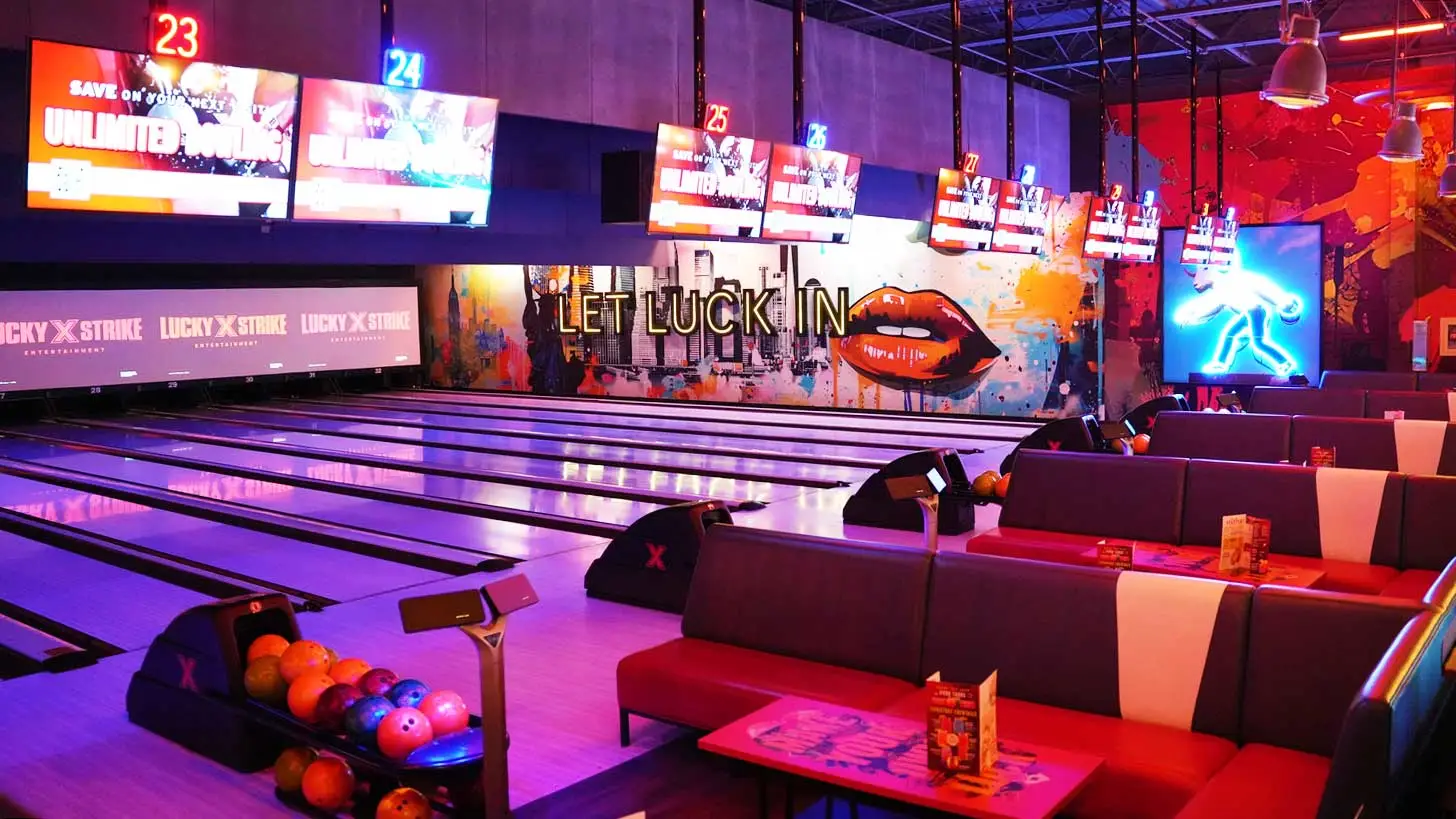 Modern bowling lanes and lounge seating at Lucky Strike with neon lighting and ball returns.