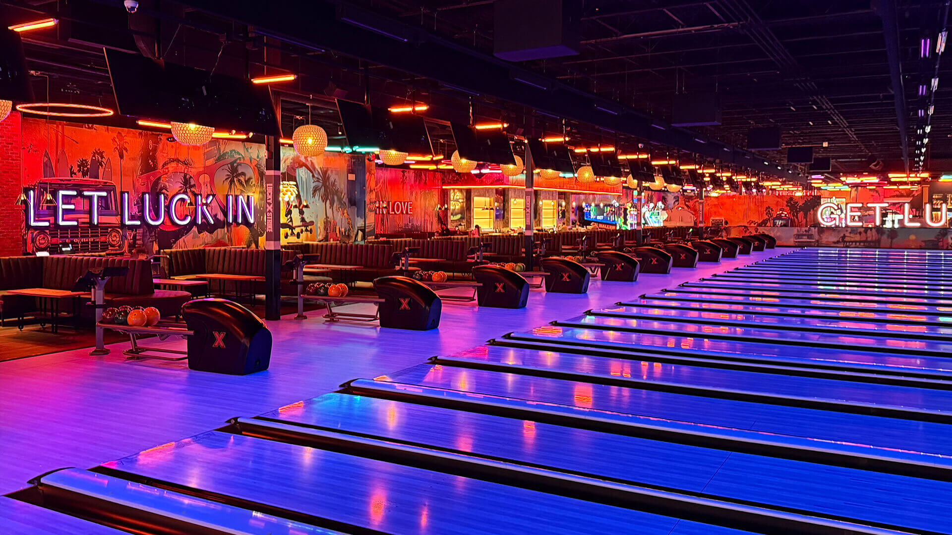 Beautiful bowling lanes under black lights with a colorful bowling center in the background