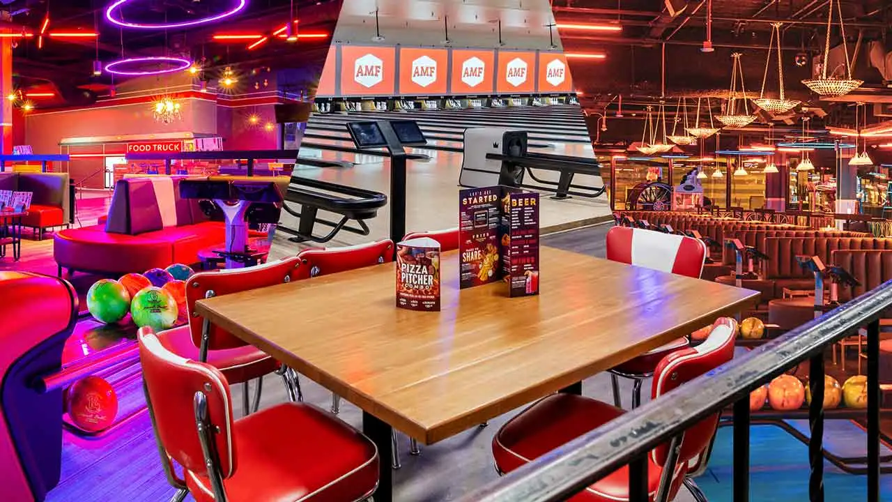 Colorful bowling balls lined up and a bar with large tvs.