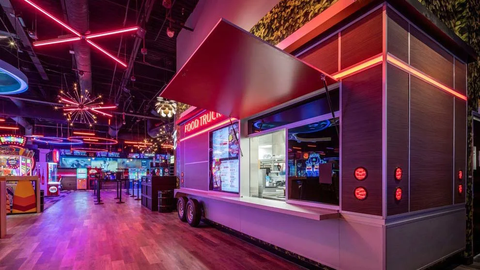 Indoor food truck counter at Lucky Strike Dania Beach with red neon signage and menu boards