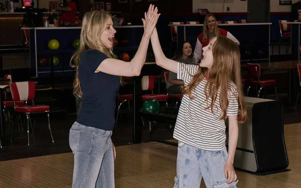 Mom and daughter high five celebrating during a game at AMF