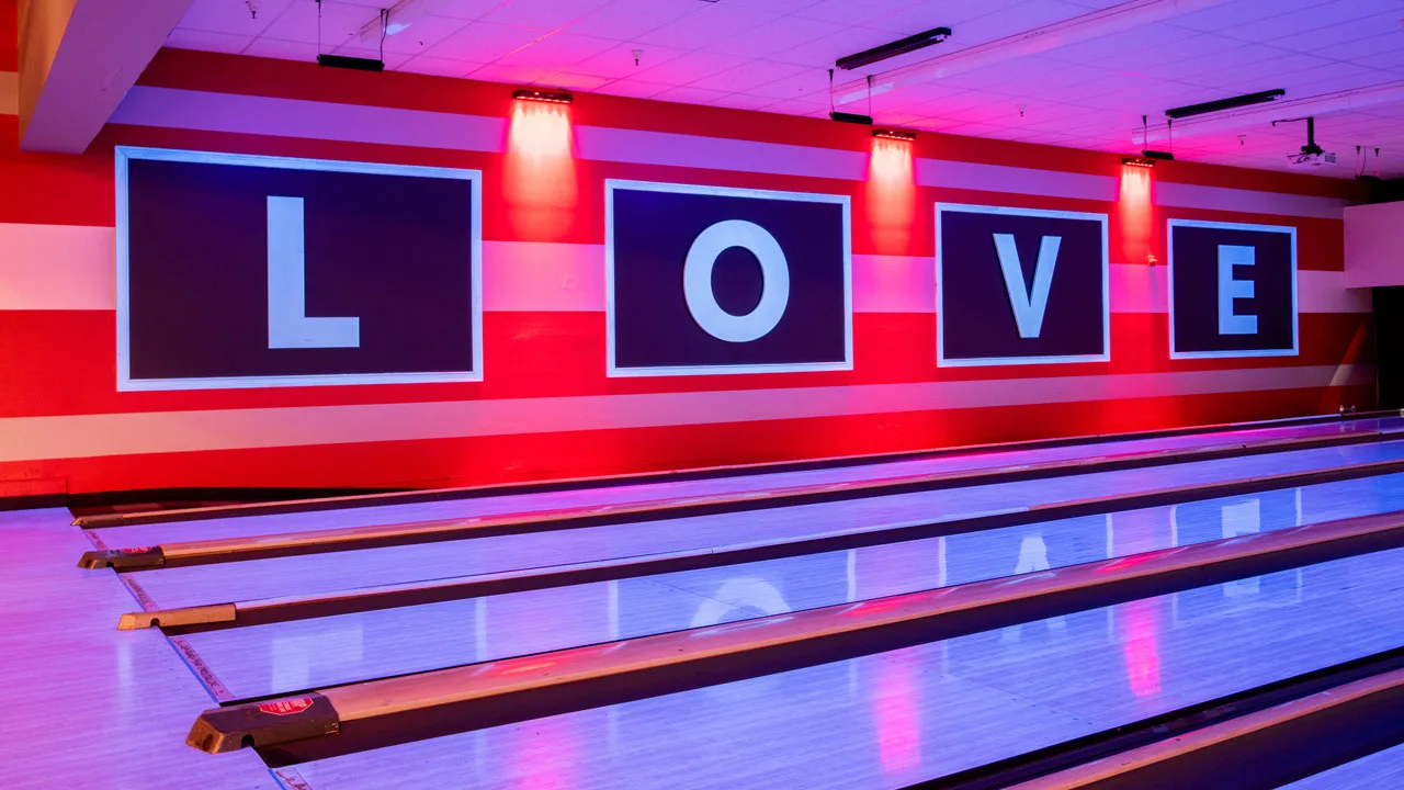Beautiful bowling lanes with black lights and a large L-O-V-E sign