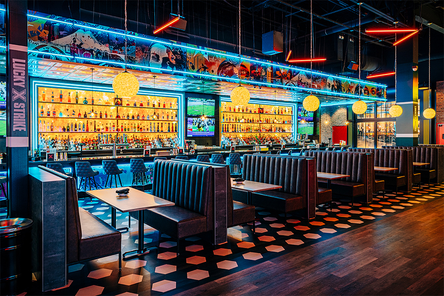 Large lounge area with large, colorfully lit bar in the background