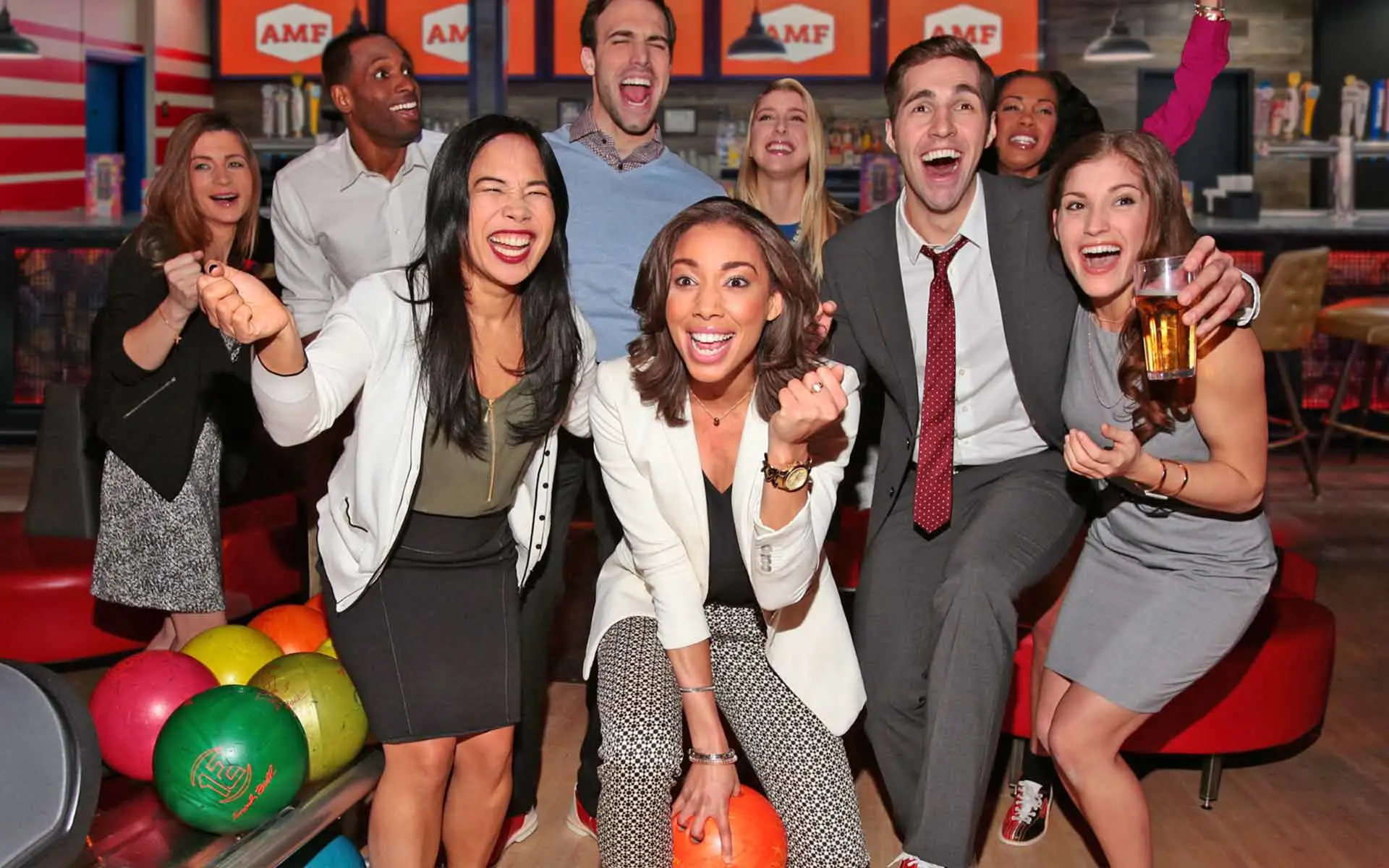 Group of adults celebrating and having fun at a bowling center.