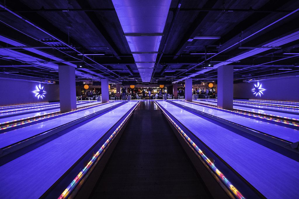 Luxury bowling lanes at Lucky Strike with vibrant blue lighting, modern lounge seating, and a sleek nightlife-inspired atmosphere.