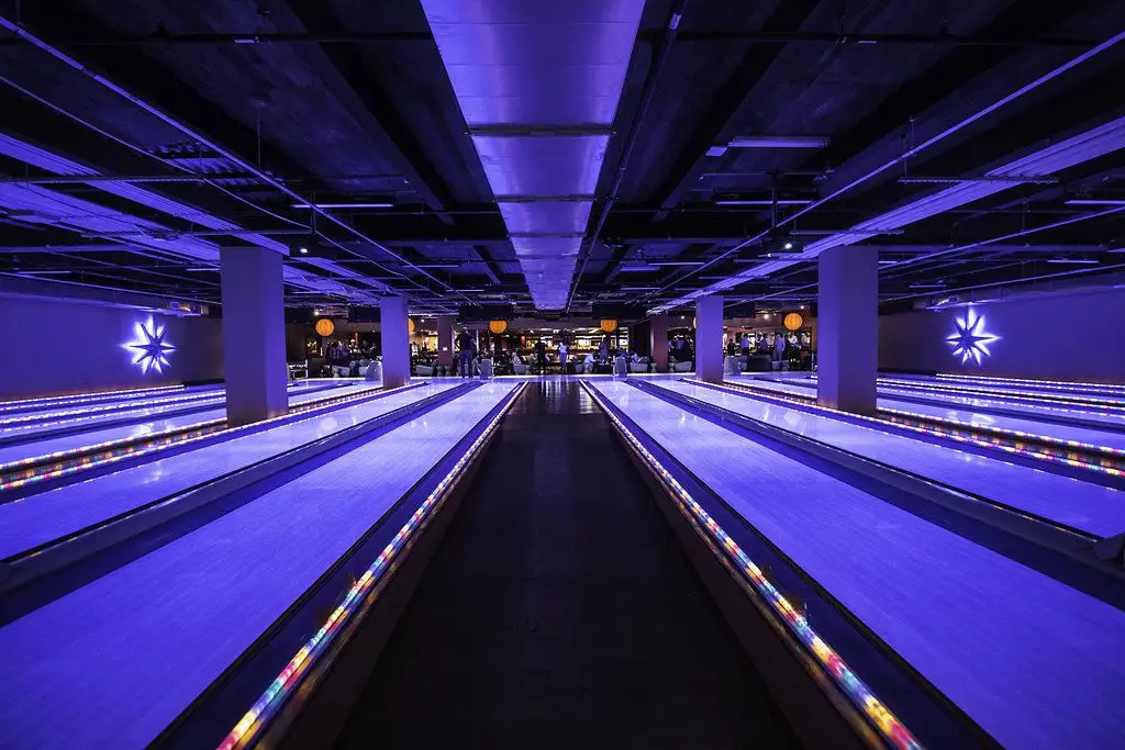 Luxury bowling lanes at Lucky Strike with vibrant blue lighting, modern lounge seating, and a sleek nightlife-inspired atmosphere.